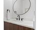 Modern half bathroom featuring a floating vanity with a white countertop and round black framed mirror at 1715 Grove St, Denver, CO 80204