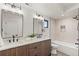 Elegant bathroom with a modern vanity, a glass shower, and a combination shower and tub at 1715 Grove St, Denver, CO 80204