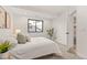 Cozy bedroom featuring neutral carpet, a black trimmed window and a door to the bathroom at 1715 Grove St, Denver, CO 80204