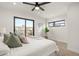 Bright bedroom with large windows, a ceiling fan, and neutral colored accents and decor at 1715 Grove St, Denver, CO 80204