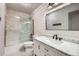 Modern bathroom with marble vanity, shiplap accent wall, and glass enclosed shower/tub combo at 10528 Applebrook Cir, Highlands Ranch, CO 80130