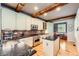 Well-appointed kitchen featuring a marble island, stainless steel appliances, exposed beams, and brick backsplash at 10528 Applebrook Cir, Highlands Ranch, CO 80130