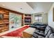 Cozy recreation room featuring a large sectional sofa, built-in shelving, and access to an outdoor patio at 10528 Applebrook Cir, Highlands Ranch, CO 80130