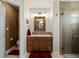 Cozy bathroom featuring a glass shower, single vanity, and decorative mirror at 13804 W 61St Cir, Arvada, CO 80004