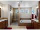 Spacious bathroom featuring a glass shower, soaking tub, double vanity, and tile flooring at 13804 W 61St Cir, Arvada, CO 80004