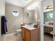 Charming bathroom featuring a round window, wood cabinet vanity, and decor at 13804 W 61St Cir, Arvada, CO 80004