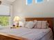 Bright bedroom featuring a wooden bed frame, striped linens, and three transom windows at 13804 W 61St Cir, Arvada, CO 80004