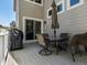 Back deck with a glass table, chairs, and a grill, perfect for outdoor dining and entertaining at 13804 W 61St Cir, Arvada, CO 80004