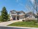 Charming two-story home featuring a well-manicured lawn and covered porch with seating at 13804 W 61St Cir, Arvada, CO 80004