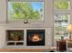 Close up view of the living room fireplace, shelving, and large picture window at 13804 W 61St Cir, Arvada, CO 80004