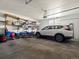 Garage with a white SUV, storage shelves, overhead door, and concrete floor at 13804 W 61St Cir, Arvada, CO 80004