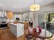Open kitchen and breakfast nook with hardwood floors, a center island, and sliding glass doors to the backyard at 13804 W 61St Cir, Arvada, CO 80004