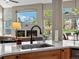 Kitchen sink overlooking the Gathering room with a fireplace and large windows, adding natural light to the home at 13804 W 61St Cir, Arvada, CO 80004