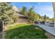 Landscaped backyard with a stone retaining wall and patio seating, perfect for relaxation at 7329 Arco Iris Ln, Castle Pines, CO 80108
