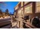 Back exterior of home with a stone patio featuring outdoor furniture and shade at 7329 Arco Iris Ln, Castle Pines, CO 80108