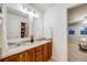 Bathroom boasts a double vanity with granite countertops and views into the bedroom at 7329 Arco Iris Ln, Castle Pines, CO 80108