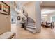 Grand foyer features a curved staircase, chandelier, and hardwood floors that provide an open and inviting entrance to the home at 7329 Arco Iris Ln, Castle Pines, CO 80108