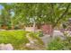 Spacious backyard with a playhouse, deck, lush lawn, and mature trees, perfect for outdoor enjoyment at 1048 N Columbine St, Golden, CO 80403