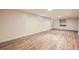 Open basement layout featuring wood-look flooring, with window and built-in shelving/drawers at 1048 N Columbine St, Golden, CO 80403