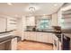 Well-lit kitchen featuring white cabinetry, black countertops, stainless appliances, and wood flooring at 1048 N Columbine St, Golden, CO 80403