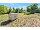 Expansive backyard featuring a playhouse surrounded by mature trees and lush green grass at 8813 Baseline Rd, Lafayette, CO 80026