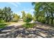 Long driveway leads to a charming ranch-style home surrounded by mature trees at 8813 Baseline Rd, Lafayette, CO 80026