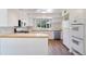 Bright kitchen with wood countertops, white cabinetry, and stainless steel appliances, offering a clean, modern space at 8813 Baseline Rd, Lafayette, CO 80026