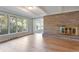 Sunny living room with a stone fireplace, hardwood floors, and large windows offering natural light and outdoor views at 8813 Baseline Rd, Lafayette, CO 80026