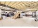 Unfinished basement with exposed ceiling, open staircase, and ample storage space at 8623 S Wadsworth Ct, Littleton, CO 80128