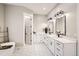 Elegant bathroom featuring double vanity, marble countertops, hexagon tile floors and modern fixtures at 8623 S Wadsworth Ct, Littleton, CO 80128