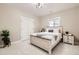 Cozy bedroom with a bed, matching nightstand, carpet, and a large window at 8623 S Wadsworth Ct, Littleton, CO 80128