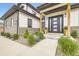 Modern home entrance featuring an elegant door, exterior lighting and manicured landscaping at 8623 S Wadsworth Ct, Littleton, CO 80128