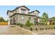 A modern home features stone accents, a driveway, and landscaping, blending contemporary and natural aesthetics at 8623 S Wadsworth Ct, Littleton, CO 80128