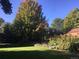 Backyard with beautiful landscaping, lush green grass, and mature trees at 7019 S Windermere St, Littleton, CO 80120