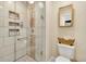 Bathroom shower featuring pebble tile, glass doors, and built-in niche for storage at 7019 S Windermere St, Littleton, CO 80120