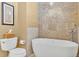 Modern bathroom showcasing a freestanding tub, mosaic tile accent wall, and neutral color scheme at 7019 S Windermere St, Littleton, CO 80120
