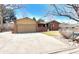 Charming single-story brick home featuring a spacious driveway and mature landscaping on a sunny day at 7019 S Windermere St, Littleton, CO 80120