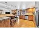 Bright open kitchen featuring hardwood floors, a breakfast bar, and stainless steel appliances at 7019 S Windermere St, Littleton, CO 80120