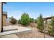 Well-maintained backyard showcasing a concrete patio, decorative stones, mature trees, and a fenced perimeter at 3995 Manorbrier Cir, Castle Rock, CO 80104