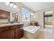 Bright bathroom showcasing a soaking tub, double vanities, and a separate glass-enclosed shower at 3995 Manorbrier Cir, Castle Rock, CO 80104
