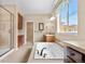 Main bathroom with dual vanities, soaking tub, walk-in shower, and natural light at 3995 Manorbrier Cir, Castle Rock, CO 80104