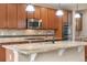 Well-equipped kitchen featuring stainless appliances, wood cabinets, and a granite-topped island with pendant lighting at 3995 Manorbrier Cir, Castle Rock, CO 80104