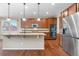 Bright kitchen with a large island, stainless steel appliances, wooden cabinetry, and hardwood floors at 3995 Manorbrier Cir, Castle Rock, CO 80104