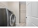 Bright laundry room featuring a modern washer and shelving at 3995 Manorbrier Cir, Castle Rock, CO 80104