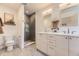 Bathroom featuring double sinks, neutral cabinets, and a tiled walk-in shower with a small niche at 2525 S Pearl St, Denver, CO 80210