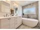 Bathroom featuring double sinks, neutral cabinets, soaking tub, and contemporary fixtures at 2525 S Pearl St, Denver, CO 80210