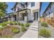 Lovely modern home features a stone porch with steps and beautiful landscaping in the front yard at 2525 S Pearl St, Denver, CO 80210