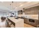 Modern kitchen with an eat-in island, stainless steel appliances, and open layout to living room at 2525 S Pearl St, Denver, CO 80210