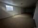 Spacious carpeted basement with white walls and a window for natural light at 3577 S Ouray Cir, Aurora, CO 80013