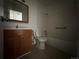 Bathroom with a wooden vanity and shower-tub combo with white tile surround at 3577 S Ouray Cir, Aurora, CO 80013